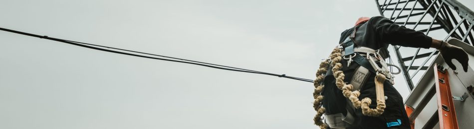 Cheerful industrial climber measuring with level tube during construction works